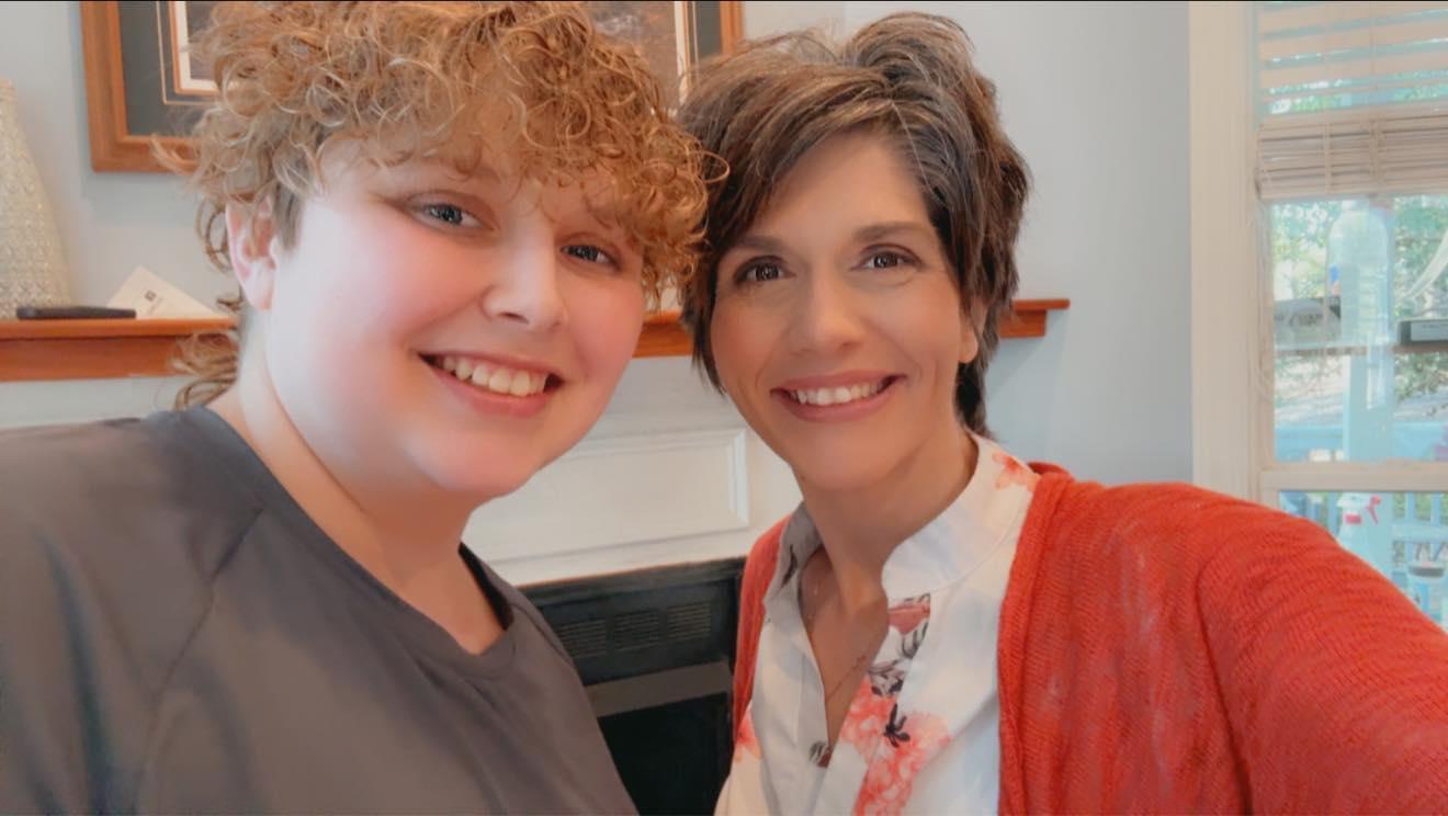 Lindsay and one of the kids leaning in together for a photo at home.