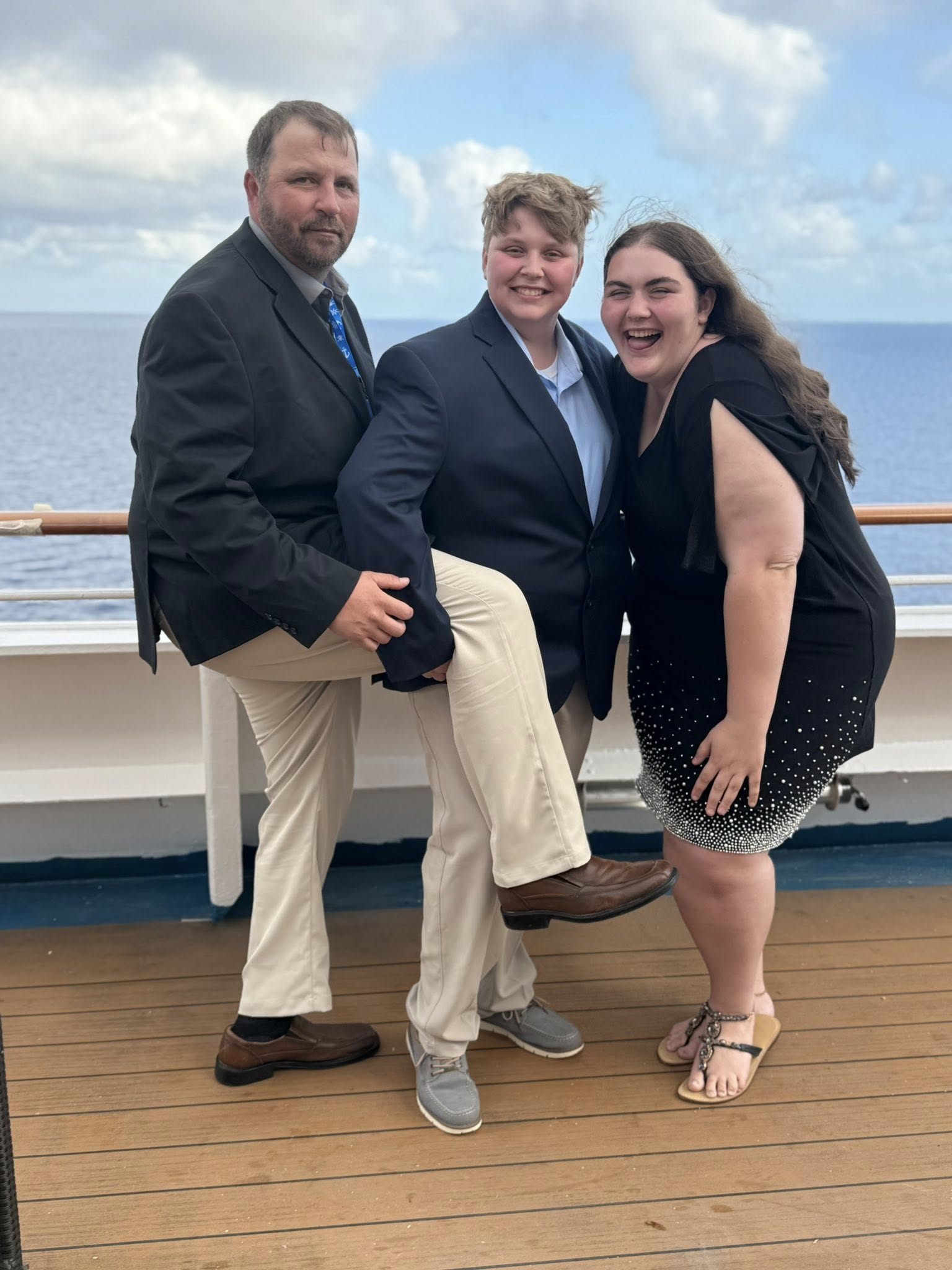 The three of us on the deck of a ship with open water behind us.