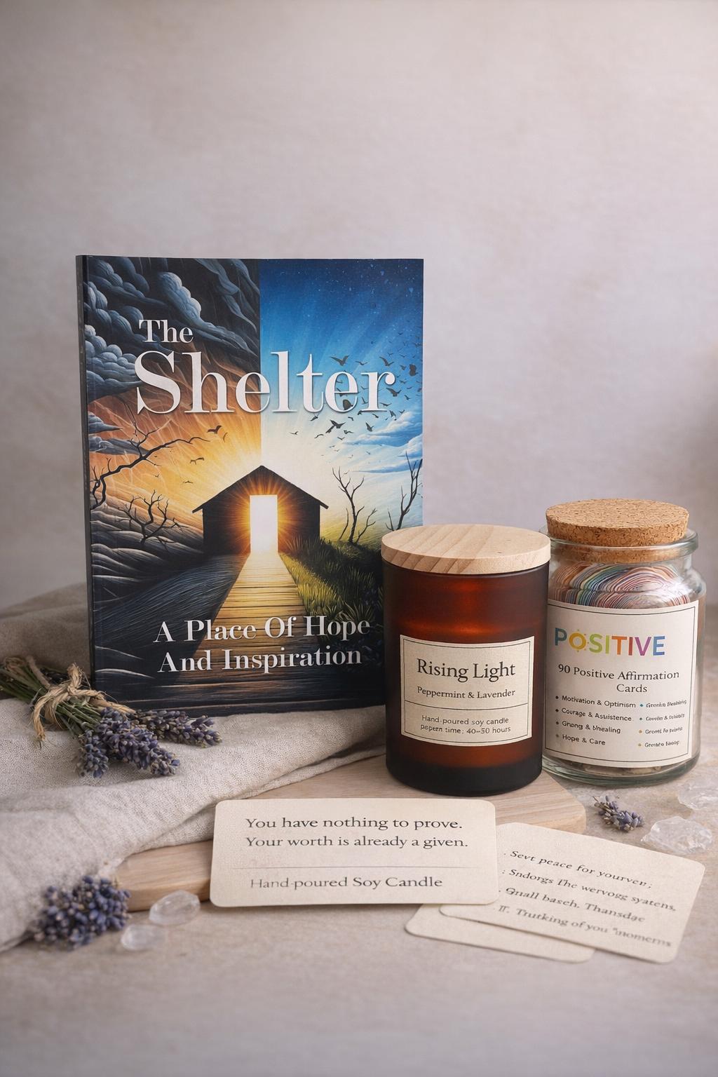 The Shelter paperback with a Rising Light candle, a positivity jar, and encouragement cards.